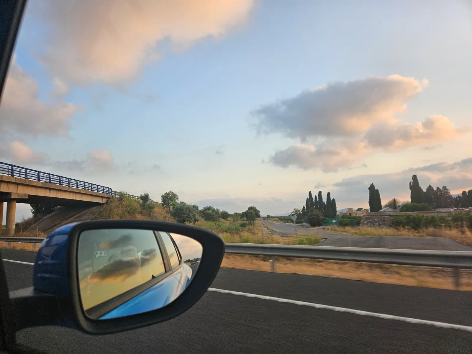 A wing mirror catching the sunset on a Spanish motorway